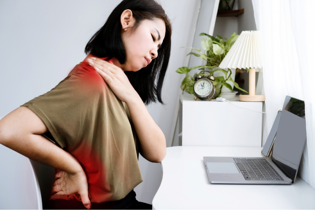 Woman at laptop touching neck and lower back with highlighted pain areas associated with poor posture